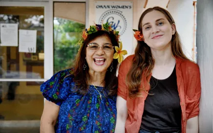 Two people smiling in front of their office.