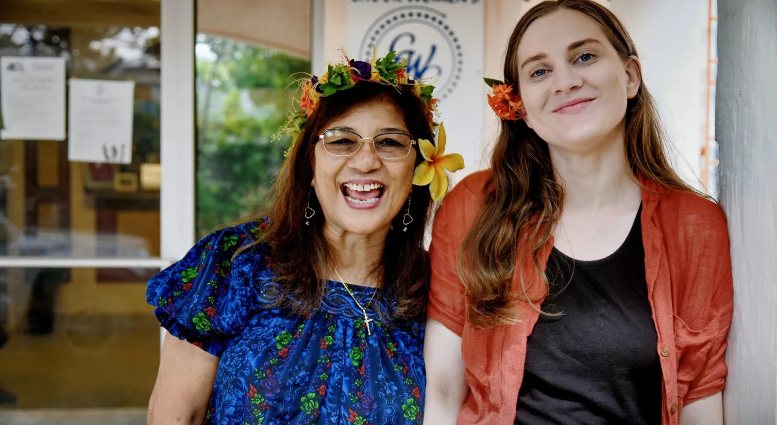 Two people smiling in front of their office.