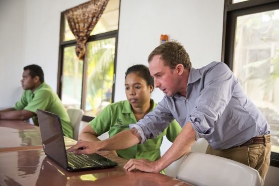 Two people working at a laptop together. Working alongside each other to get the task done.