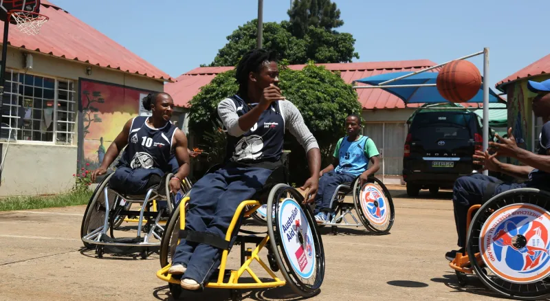 A group of people in wheelchairs playing basketball