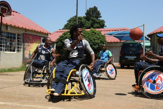 A group of people in wheelchairs playing basketball
