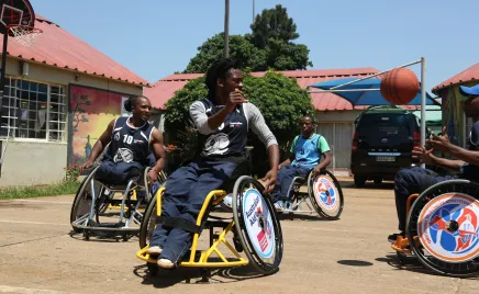 A group of people in wheelchairs playing basketball