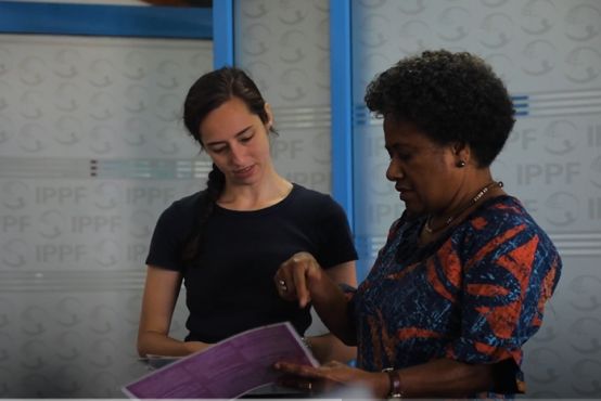 Two women talking and looking at a document together