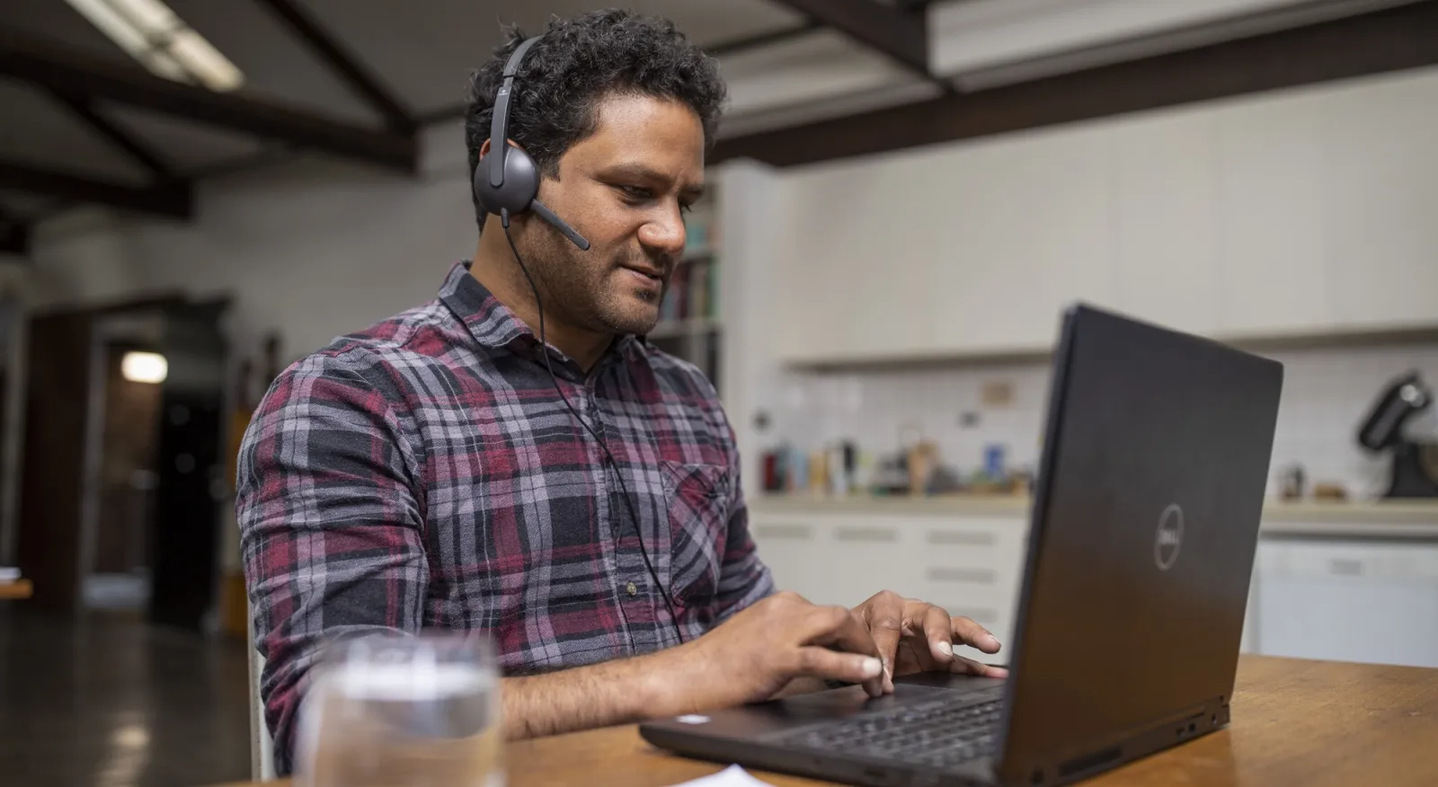 Man on this computer working remotely from his desk.