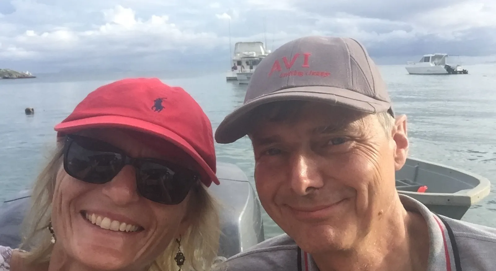 A couple pose together for a photo on a boat.