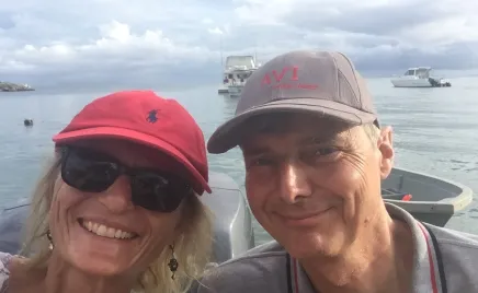 A couple pose together for a photo on a boat.