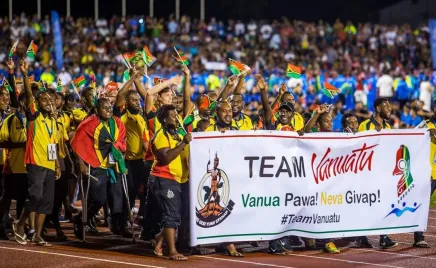 A team of athletes from Vanuatu holding up little flags of Vanuatu.