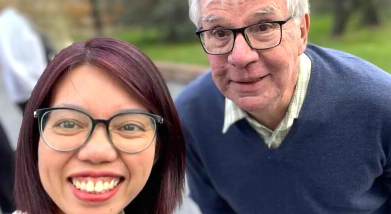 Two people wearing glasses stand next to each other.