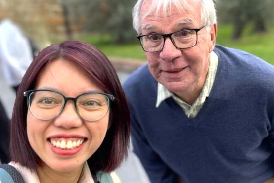 Two people wearing glasses stand next to each other.