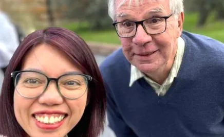 Two people wearing glasses stand next to each other.